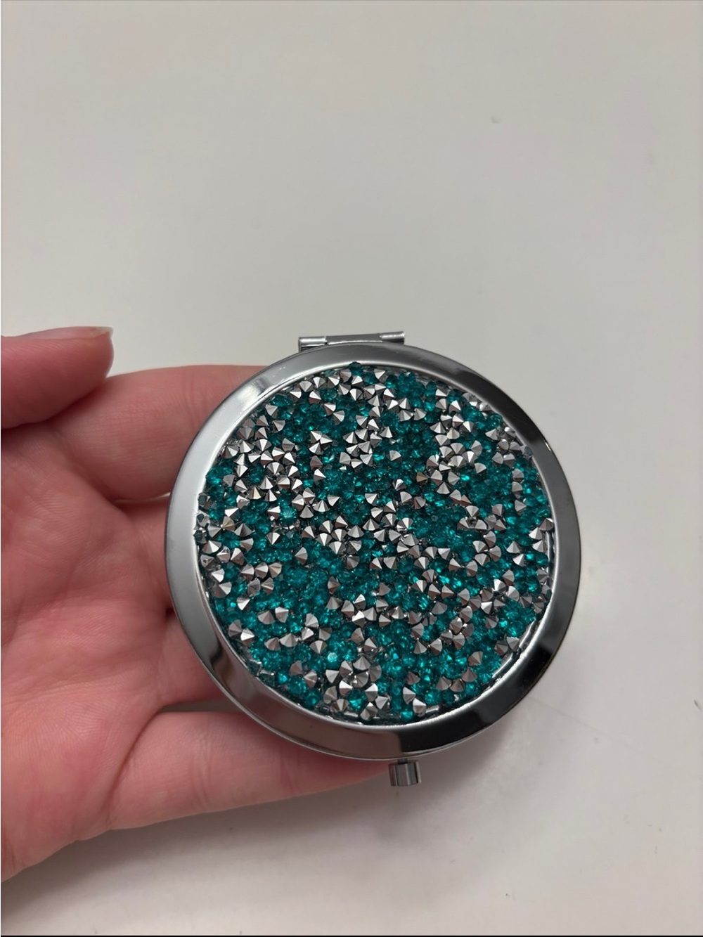 round silver-tone compact pocket makeup mirror with teal and silver rhinestone